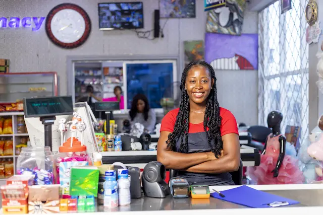 smiling-african-american-woman-black-apron-as-cashier-cash-register-supermarket