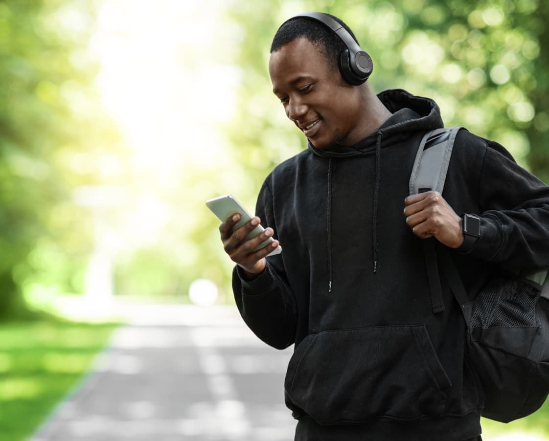 positive-black-man-with-wireless-headset-using-pho-2022-12-16-08-47-15-utc